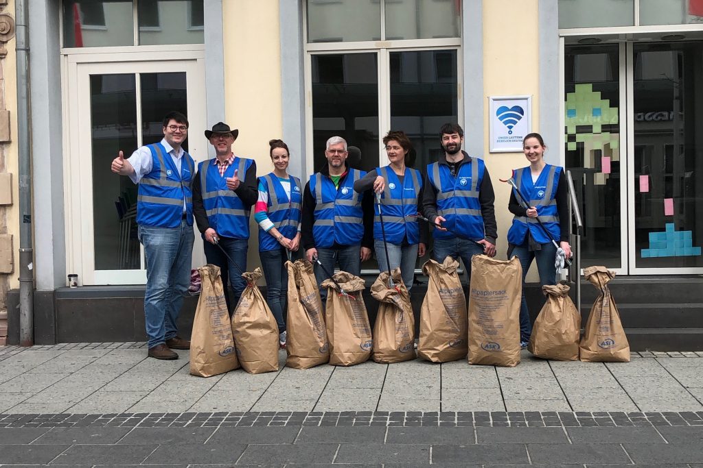 Team der KL.digital GmbH vor dem Büro in der Bahnhofstraße nach der Lautrer Kehrwoche. Vor ihnen Müllsäcke