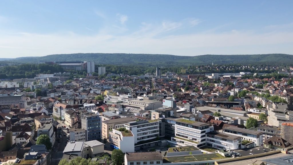Stadtansicht von Kaiserslautern: viele Häuser, das Fußballstadion und der Pfälzer Wald