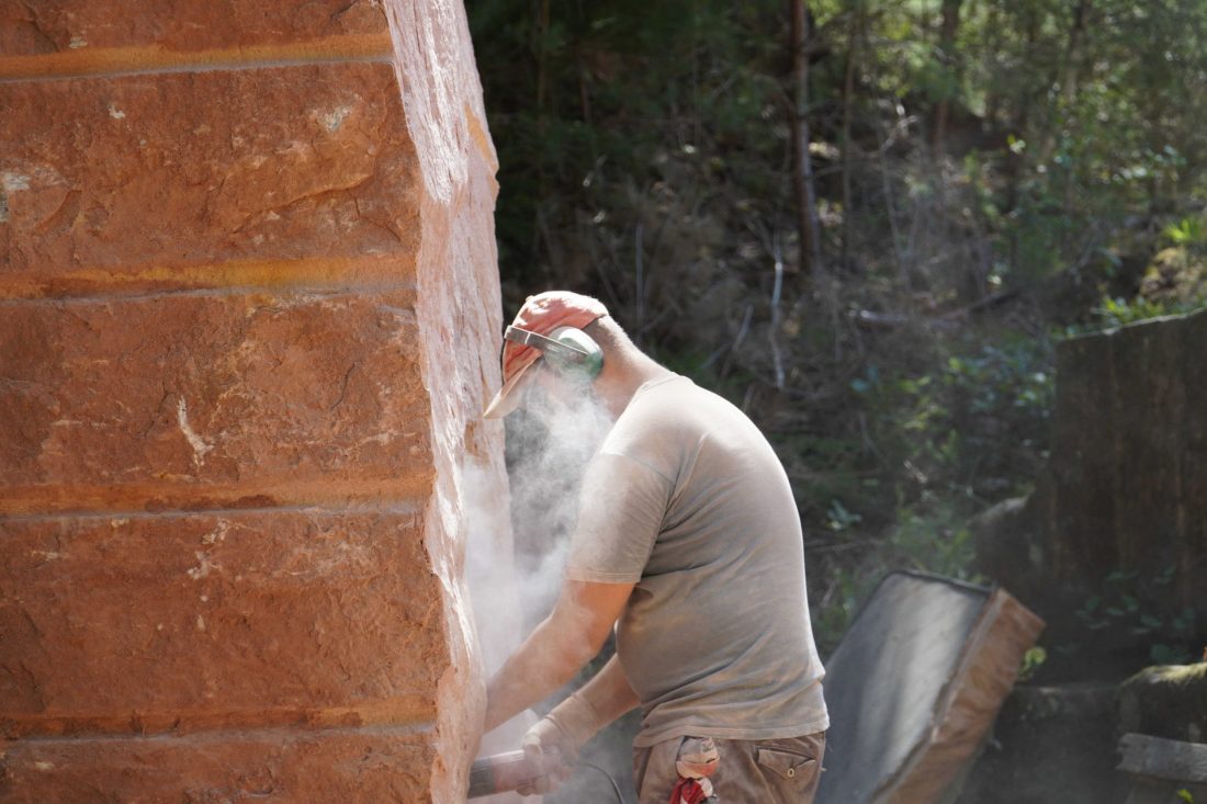 Ein Mann arbeitet an einem Kunstwerk im Steinbruch