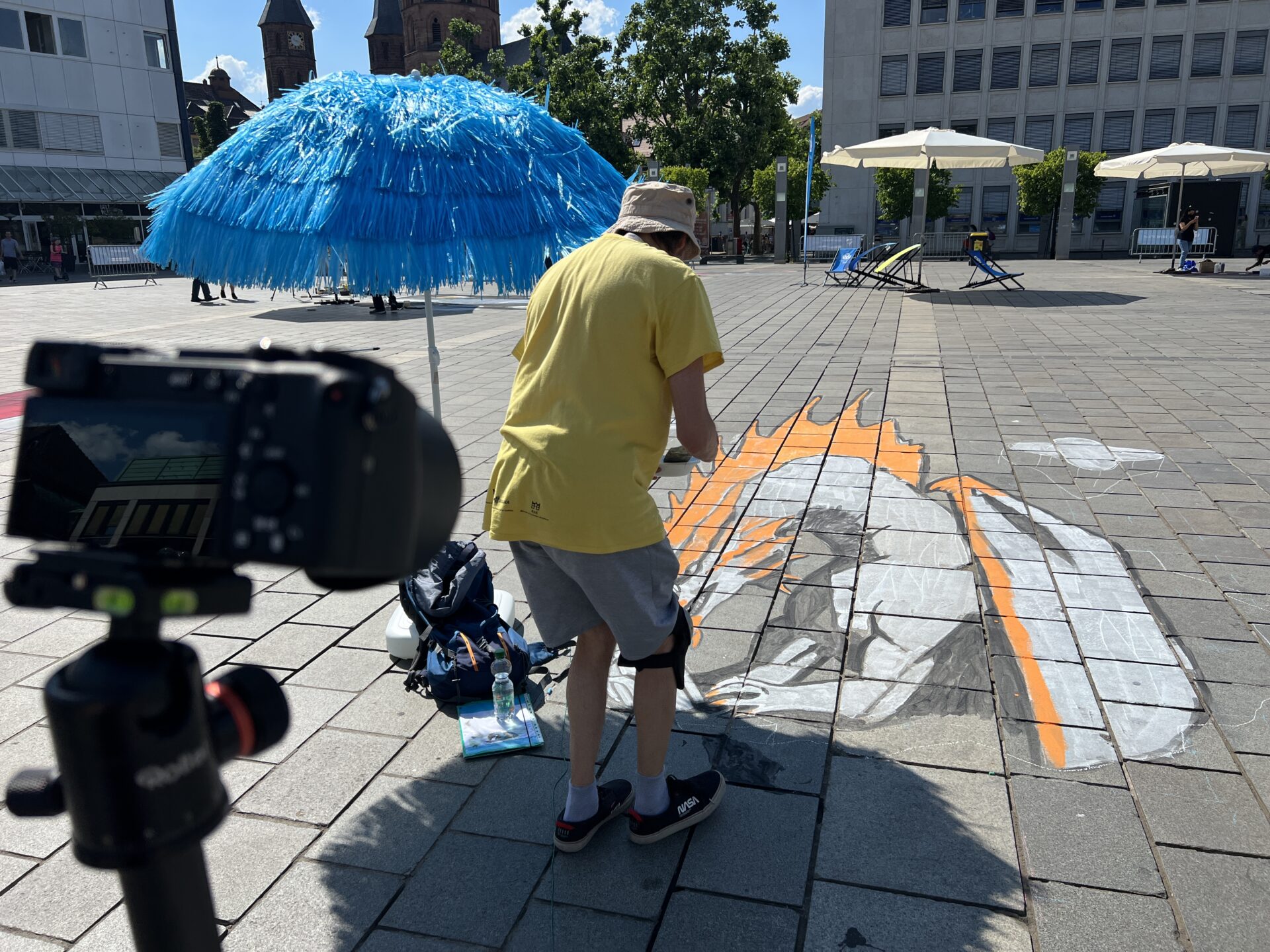 Ein mann steht vor einem Straßenmalerei-Kunstwerk auf dem Boden