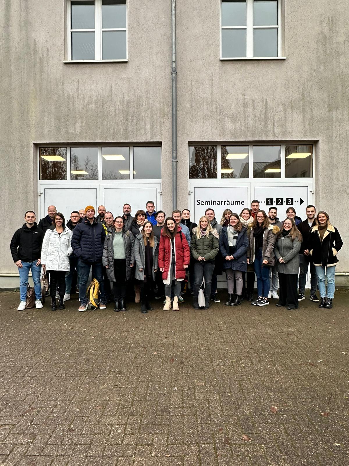 Eine Gruppe aus knapp 30 Personen steht in einem gepflasterten Außenbereich.